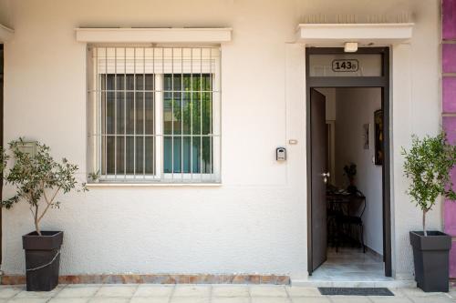 a front door of a white house with a window at Zoufi Cozy Living in Patra