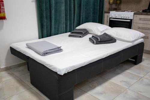 a bed with white sheets and towels on it at Zoufi Cozy Living in Patra