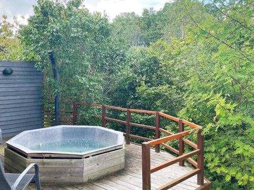a hot tub on a deck with a wooden railing at 6 person holiday home in GRÄNNA in Gränna