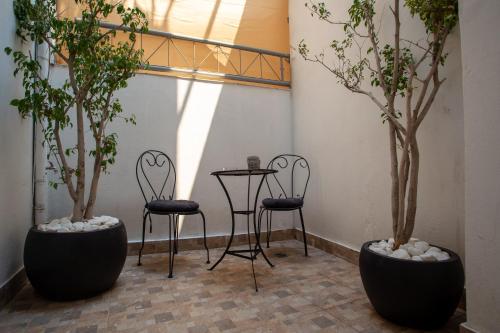 two chairs and a table in a room with trees at Zoufi Cozy Living in Patra