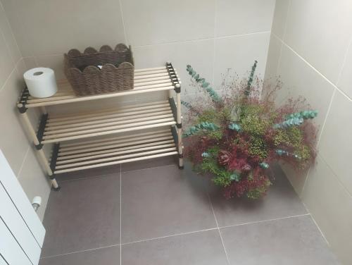 a bathroom with a bench and flowers on the floor at Ático Vista Alegre in Lerma
