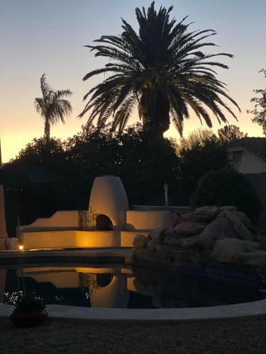 a sunset over a pool with palm trees in the background at Private Tuscany Oasis with Pool - Perfect for families, couples or business travelers home in Phoenix