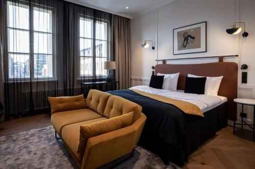 a bedroom with a bed and a couch at Scandic Grand Central Helsinki in Helsinki