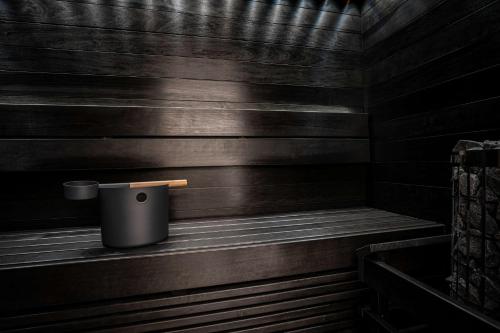 a trash can sitting on a wooden bench in a sauna at Scandic Grand Central Helsinki in Helsinki