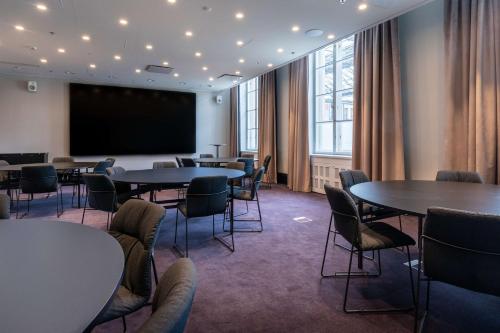 a conference room with tables and chairs and a projection screen at Scandic Grand Central Helsinki in Helsinki