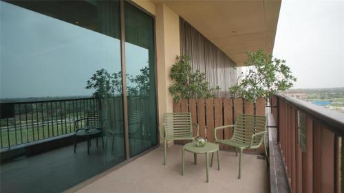 a balcony with chairs and tables on a building at Gift City Club, a member of Radisson Individuals in Gandhinagar