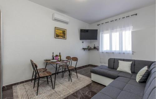 a living room with a couch and a table with chairs at Amazing Apartment In Kraljevica With Wifi in Kraljevica