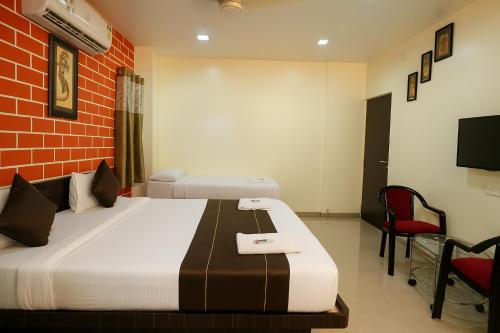 a hotel room with a bed and a tv at Hotel Avon International in Aurangabad