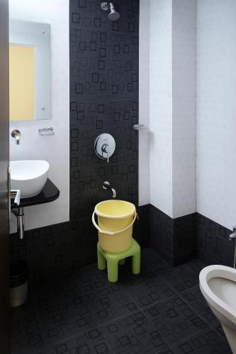 a bathroom with a yellow toilet and a sink at Hotel Avon International in Aurangabad