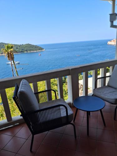 a balcony with chairs and a table and the ocean at Apartment Perica in Dubrovnik