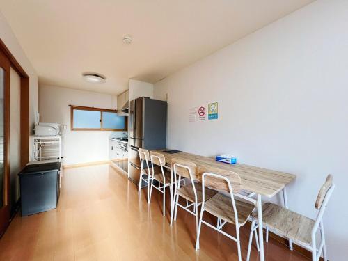 a kitchen with a long wooden table and chairs at Osaka Enso無料駐車場ありUSJまで15分難波へ15分電車直通 in Osaka