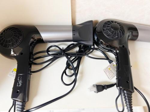 a blow dryer on a wall with cables at Osaka Enso無料駐車場ありUSJまで15分難波へ15分電車直通 in Osaka