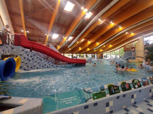 a large indoor swimming pool with a slide at Era Apartman in Harkány