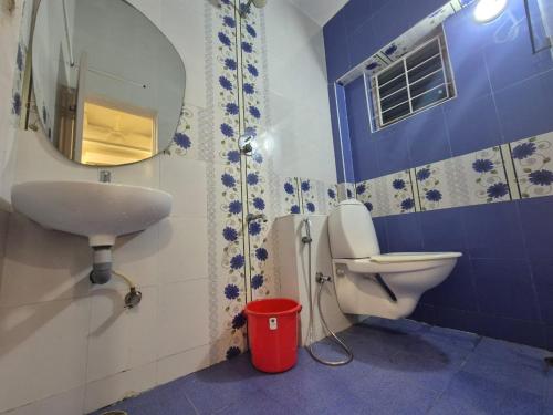 a bathroom with a sink and a toilet and a mirror at Hotel auroville grand in Covelong
