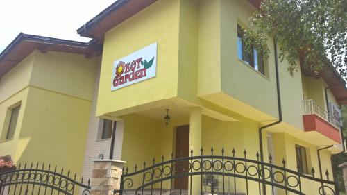a large yellow building with a sign on it at Kot Garden Guest House in Sapareva Banya