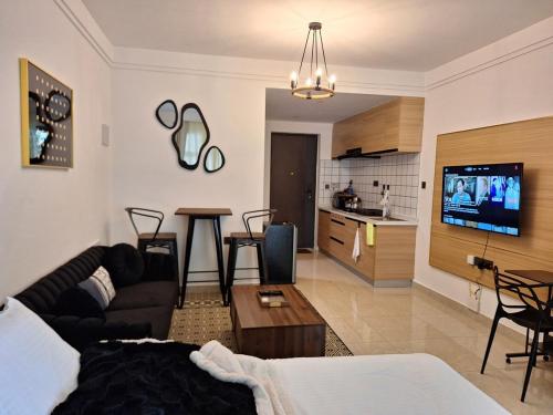 een woonkamer met een bank en een tafel en een keuken bij Luxury studio At The Loftel ruaka in Ruaka