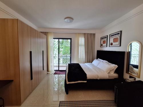 a bedroom with a bed and a sliding glass door at Luxury studio At The Loftel ruaka in Ruaka