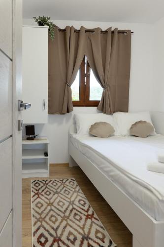 a bedroom with a white bed with a window at Seren Natura Retreat in Sebeşu de Sus