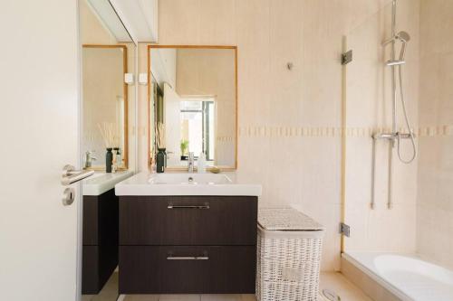a bathroom with a sink and a mirror and a tub at Private Pool Chiado Gem, Patio Retreat wAC in Lisbon