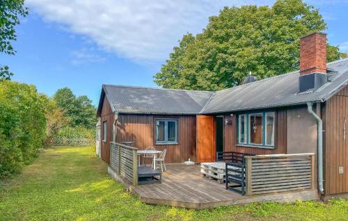 にあるNice Home In Gotlands Tofta With Wifiの木製デッキとテーブル付きの小さな家