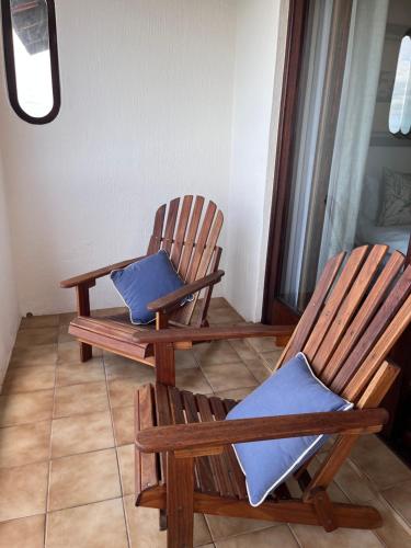 two wooden rocking chairs sitting in a room at Vistas al Mar in Groot Brak Rivier