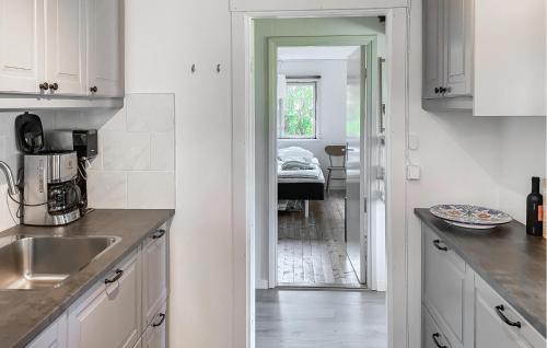にあるNice Home In Gotlands Tofta With Wifiの白いキャビネットとシンク付きのキッチン、