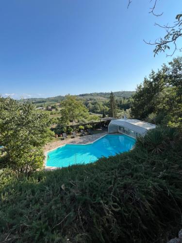 a swimming pool in the middle of a grassy hill at Villa Caterina 1 by falcony apartments in Montespertoli