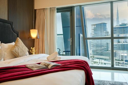 a hotel room with a bed and a large window at Luxurious 2BDR Apartment in Paramount Towers with Burj Khalifa Views in Dubai