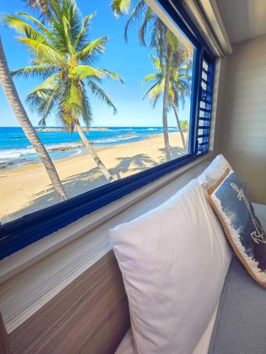 a room with a window with a view of the beach at Brusea by the Beach in Camuy