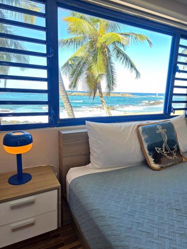 a bedroom with a bed with a view of the beach at Brusea by the Beach in Camuy
