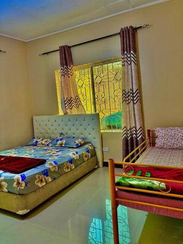 a bedroom with two beds and a window at Isamilo House in Mwanza