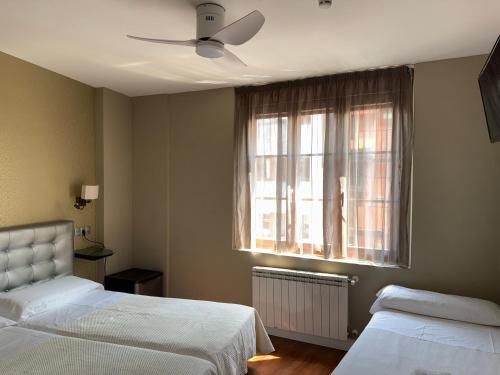 a bedroom with two beds and a window at Hotel Boutique Rosal Oviedo in Oviedo