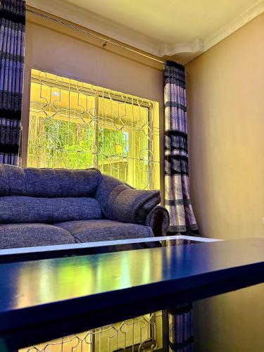a living room with a couch and a window at Isamilo House in Mwanza