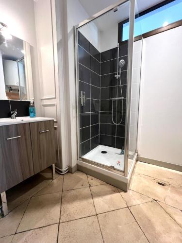 une salle de bain avec une douche avec une porte vitrée dans l'établissement Le NEW YORKEUR Plein coeur de Poitiers, à Poitiers