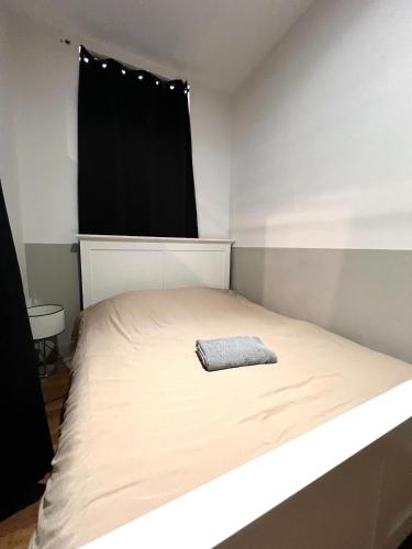 - une petite chambre avec un lit et une serviette dans l'établissement Le NEW YORKEUR Plein coeur de Poitiers, à Poitiers