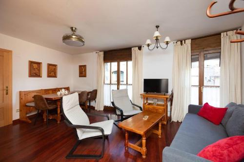 ein Wohnzimmer mit Sofa und Tisch in der Unterkunft Parque d'Arratiecho l Wifi l Céntrico l Amplio in Biescas