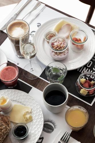 a table with plates of food and glasses of wine at Hotel Hans in Copenhagen