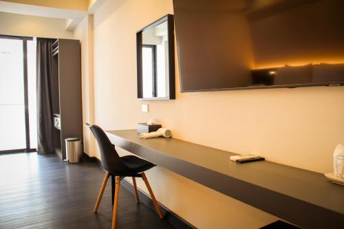 a desk in a room with a chair and a mirror at iThaphae Hotel in Chiang Mai
