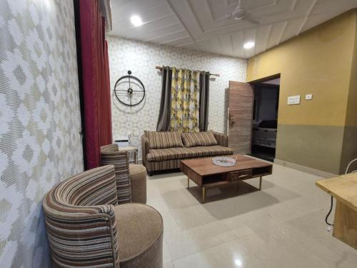 a living room with a couch and a table at Hotel auroville grand in Covelong