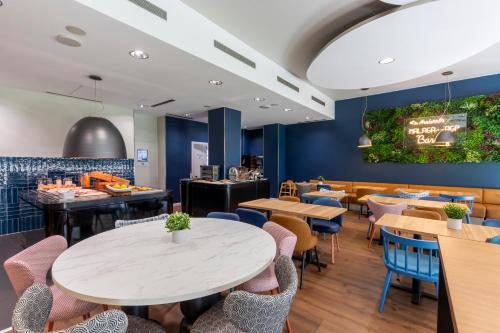 a dining room with tables and chairs at Travelodge Málaga Airport in Málaga