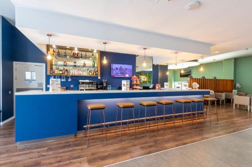a bar in a restaurant with stools at Travelodge Málaga Airport in Málaga