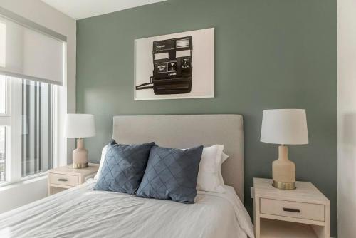 a bedroom with a bed with two night stands and two lamps at Landing Apartments near Sun City Center and Riverview in Wimauma