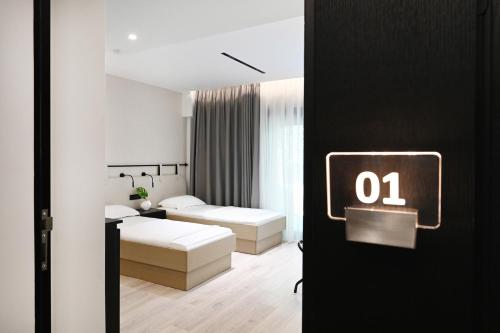 a bedroom with two beds and a sign with the number at ICON Urban Living in Thessaloniki
