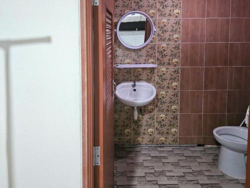 a bathroom with a sink and a toilet and a mirror at Norn nee Na Hostel นอน นี่ นะ โฮสเทล in Ban Non Na Yao