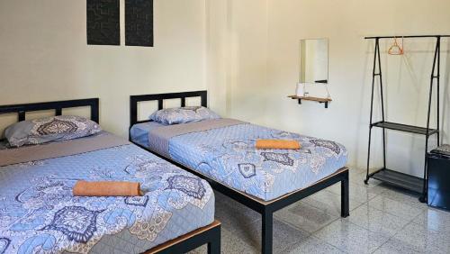 two beds sitting next to each other in a room at Norn nee Na Hostel นอน นี่ นะ โฮสเทล in Ban Non Na Yao