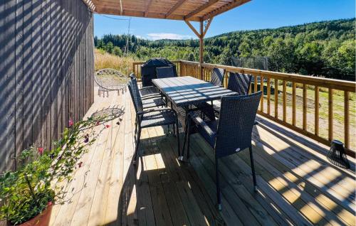 a wooden deck with a table and chairs on it at Nice Home In Åstenäs With Wifi 