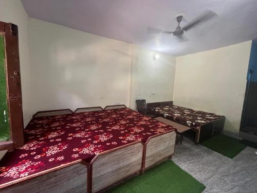 a bedroom with a bed with a red bedspread at Devdarshan Hotel & Tourist Guest House Sonprayag in Jāmb