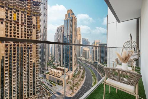 a balcony with a chair and a view of a city at City Views, Pool & Gym Near Iconic Burj Khalifa in Dubai