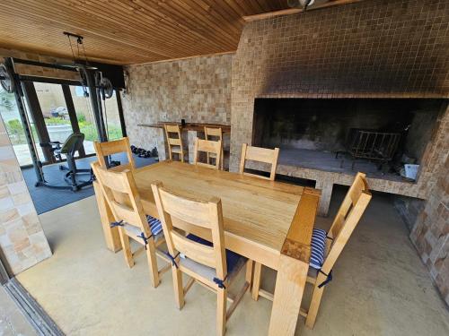 a wooden table and chairs and a fireplace at Ocean Glimpse in Cape Town