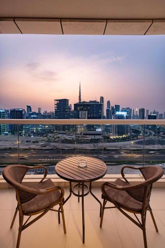 a table and chairs on a balcony with a view of a city at Luxurious 2BDR Apartment in Paramount Towers with Burj Khalifa Views in Dubai